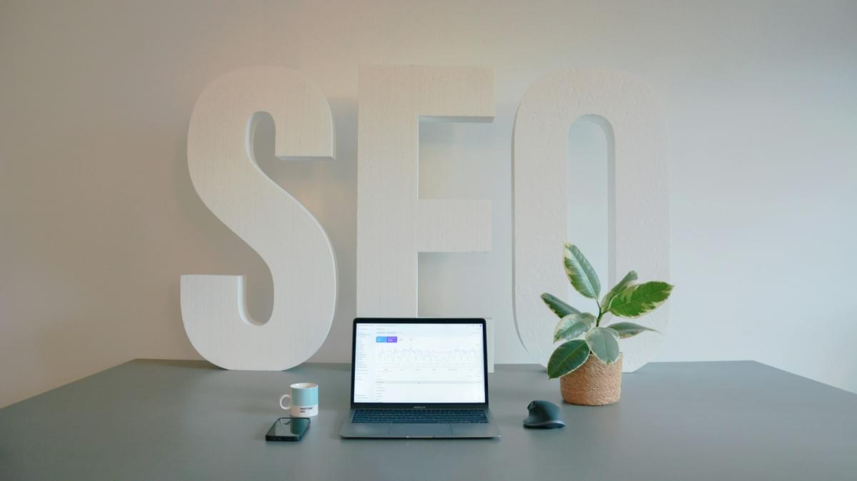 An organized SEO workspace with a laptop and large SEO letters An organized SEO workspace with a laptop and large SEO letters