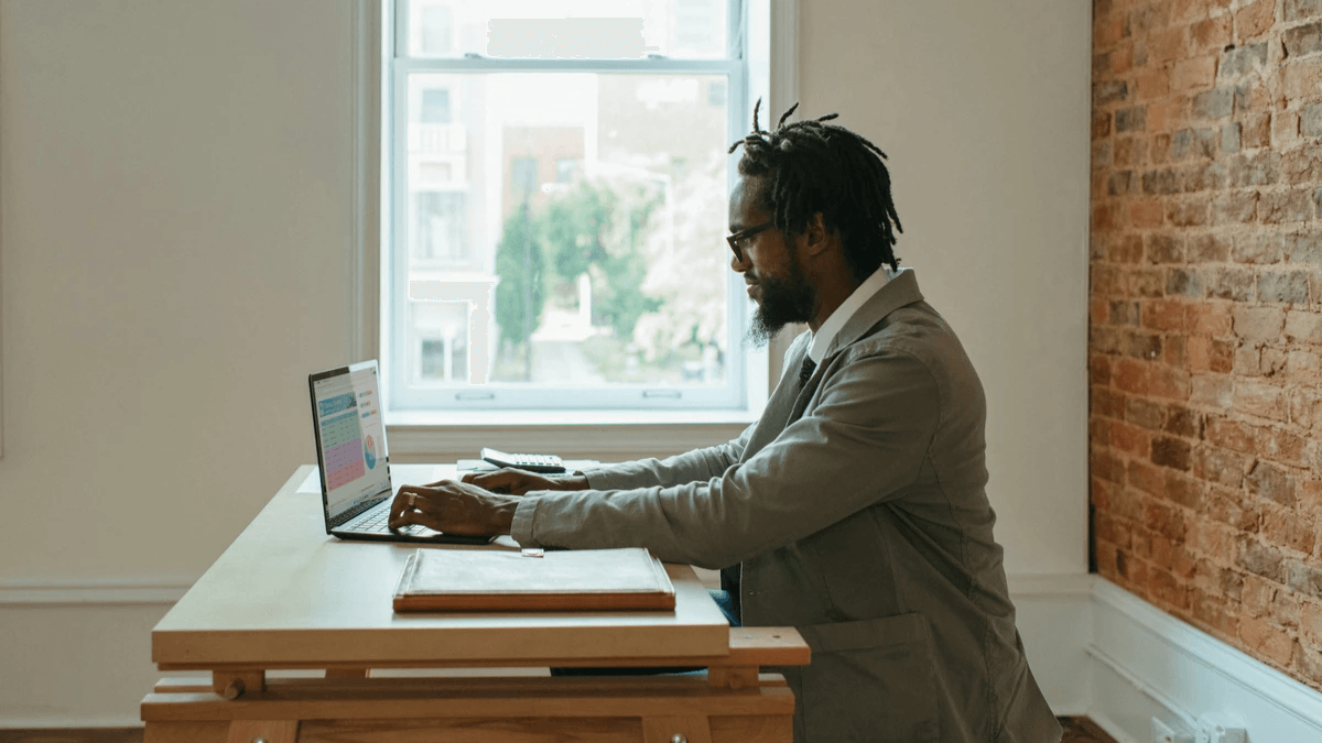 A business professional entering information on a laptop during a work session A business professional entering information on a laptop during a work session