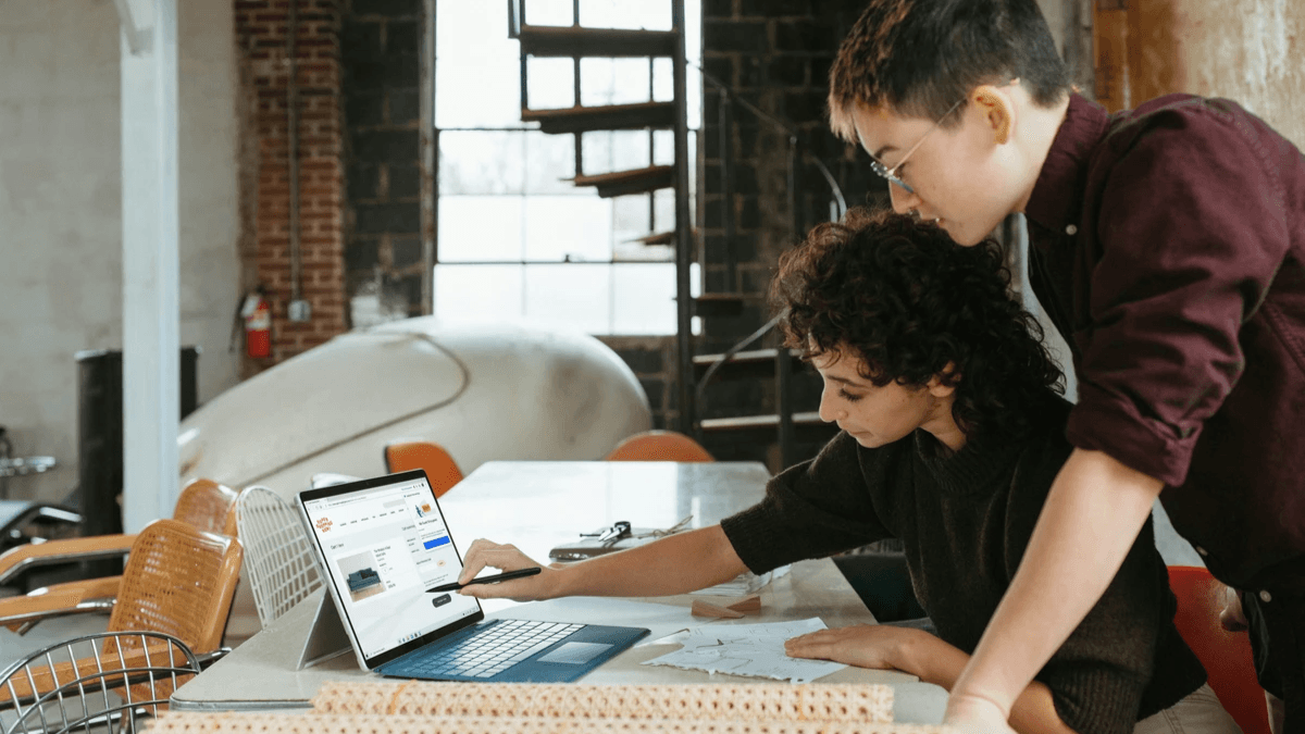 Marketing teammates reviewing an advertisement and its campaign landing page together Marketing teammates reviewing an advertisement and its campaign landing page together