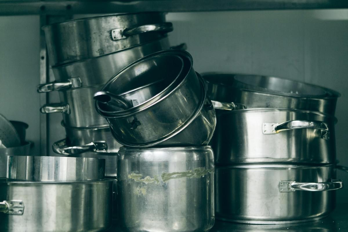 Aluminum cookware being inspected in factory setting. Aluminum cookware being inspected in factory setting.