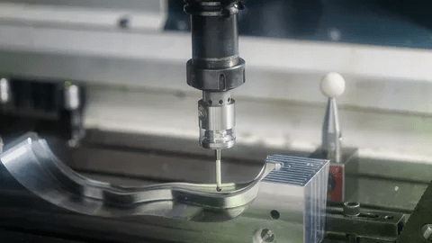 CNC machine operator working on precision metal part CNC machine operator working on precision metal part
