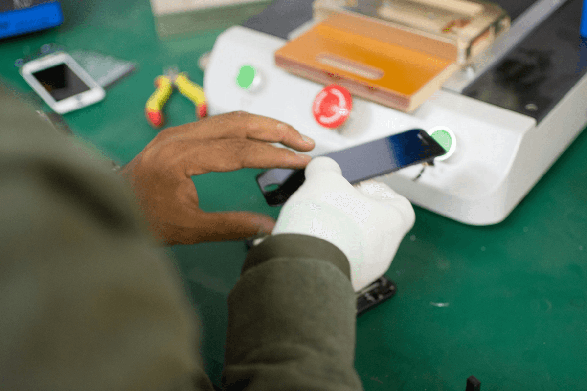Inspecting a smartphone during quality control process Inspecting a smartphone during quality control process