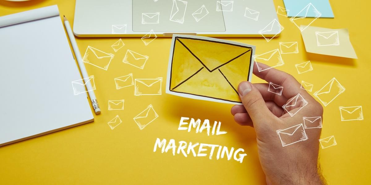 imagen recortada de un hombre que sostiene un sobre cerca de un ordenador portátil con las letras "email marketing" e iconos de correo electrónico imagen recortada de un hombre que sostiene un sobre cerca de un ordenador portátil con las letras "email marketing" e iconos de correo electrónico