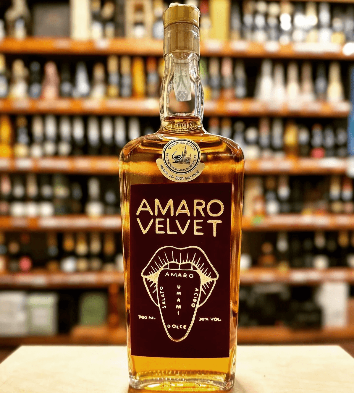 Bottiglia di Amaro Velvet Mr.Liquor esposta su bancone di enoteca toscana, liquore artigianale botanico premiato. Bottiglia di Amaro Velvet Mr.Liquor esposta su bancone di enoteca toscana, liquore artigianale botanico premiato.