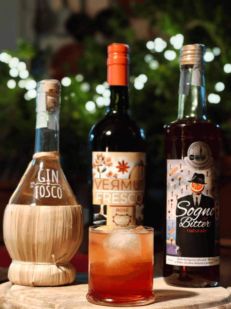 Negroni Toscano MR Liquor preparato con Gin Tosco, Sogno Bitter e Vermut Fresco, cocktail natalizio servito con cannella e ghiaccio grande Negroni Toscano MR Liquor preparato con Gin Tosco, Sogno Bitter e Vermut Fresco, cocktail natalizio servito con cannella e ghiaccio grande