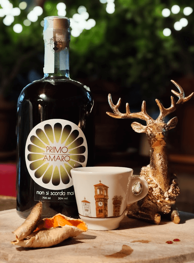 Primo Amaro MR Liquor servito con una tazzina di caffè espresso, digestivo perfetto per le cene e i dolci di Natale Primo Amaro MR Liquor servito con una tazzina di caffè espresso, digestivo perfetto per le cene e i dolci di Natale
