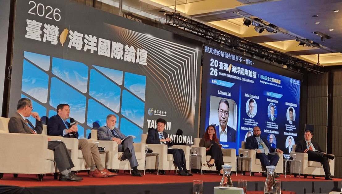 Five men and one woman sit in large padded chairs on the stage of the Taiwan International Ocean Forum. A sign in Chinese for the event and a projected slide with all of their headshots and titles are behind them. John Bradford holds the mic and is speaking thoughtfully. Jeffrey Payne is further down the line of panelists and is watching John. Five men and one woman sit in large padded chairs on the stage of the Taiwan International Ocean Forum. A sign in Chinese for the event and a projected slide with all of their headshots and titles are behind them. John Bradford holds the mic and is speaking thoughtfully. Jeffrey Payne is further down the line of panelists and is watching John.