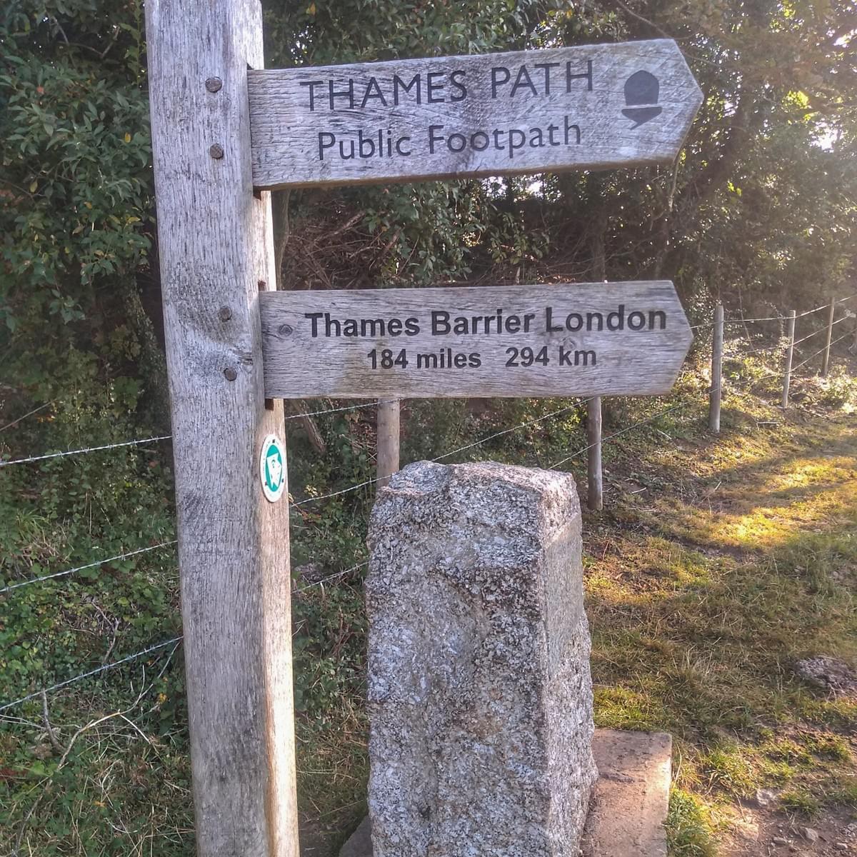 SIgnpost and stone in Kemble marking the source of the River Thames and the beginning of the Thames Path national trail route SIgnpost and stone in Kemble marking the source of the River Thames and the beginning of the Thames Path national trail route