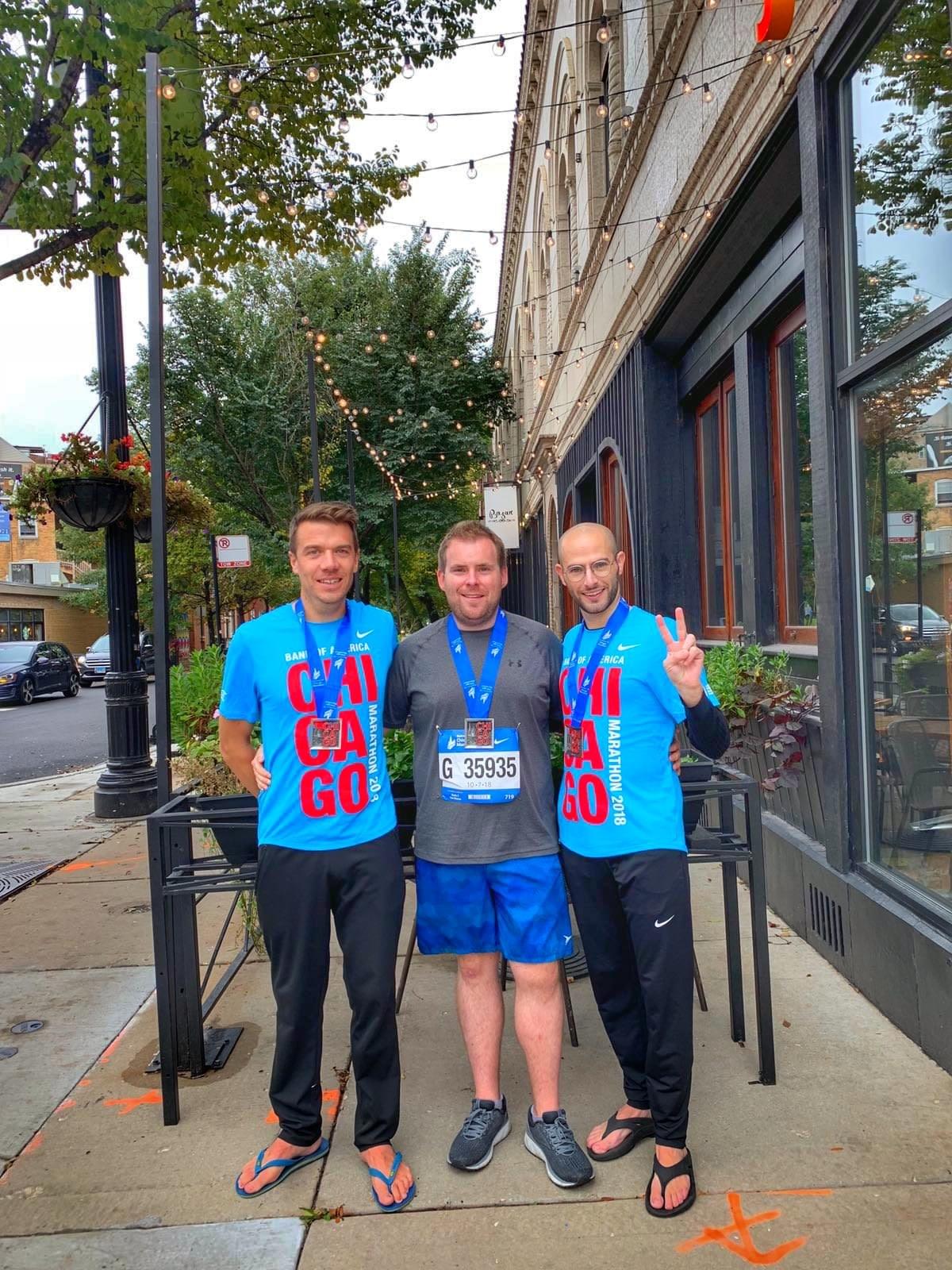 A group of three runners show off the 2018 Chicago Marathon official t-shirts and medals A group of three runners show off the 2018 Chicago Marathon official t-shirts and medals