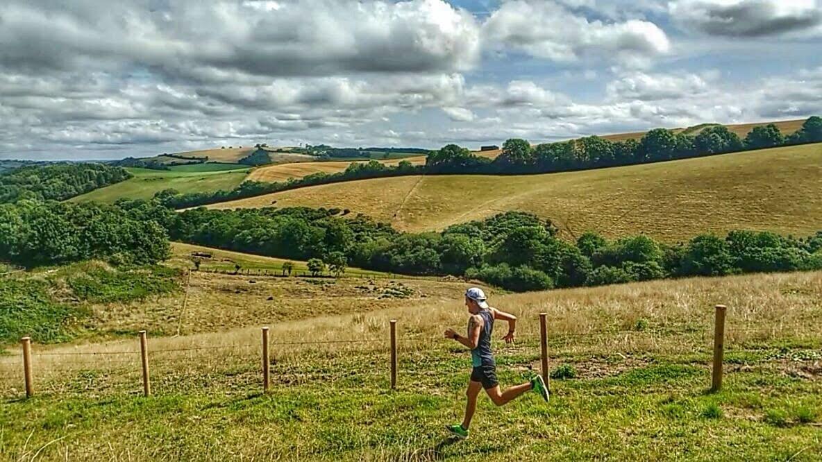 Running down a hilly trail on Dartmoor, UK. Rolling hills in the background. Running down a hilly trail on Dartmoor, UK. Rolling hills in the background.