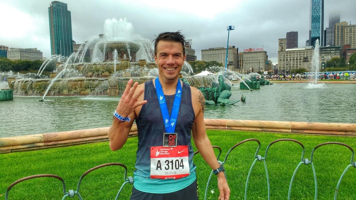 A runner shows off the 2018 Chicago Marathon finishers medal in front of Buckingham Fountain in Grant Park A runner shows off the 2018 Chicago Marathon finishers medal in front of Buckingham Fountain in Grant Park