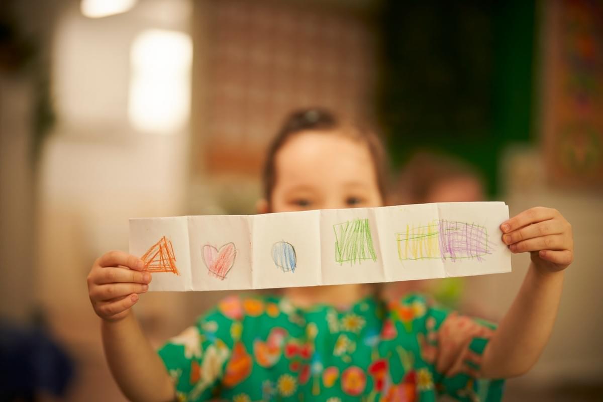 Child proudly showing their drawing Child proudly showing their drawing