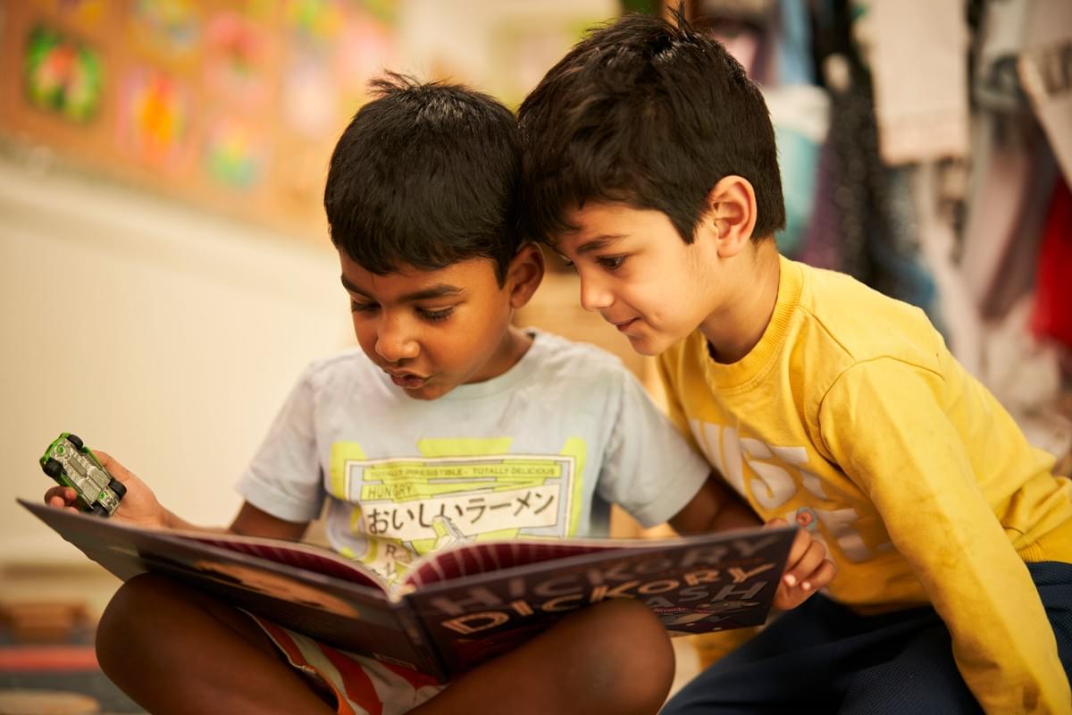 Two children reading a book together Two children reading a book together