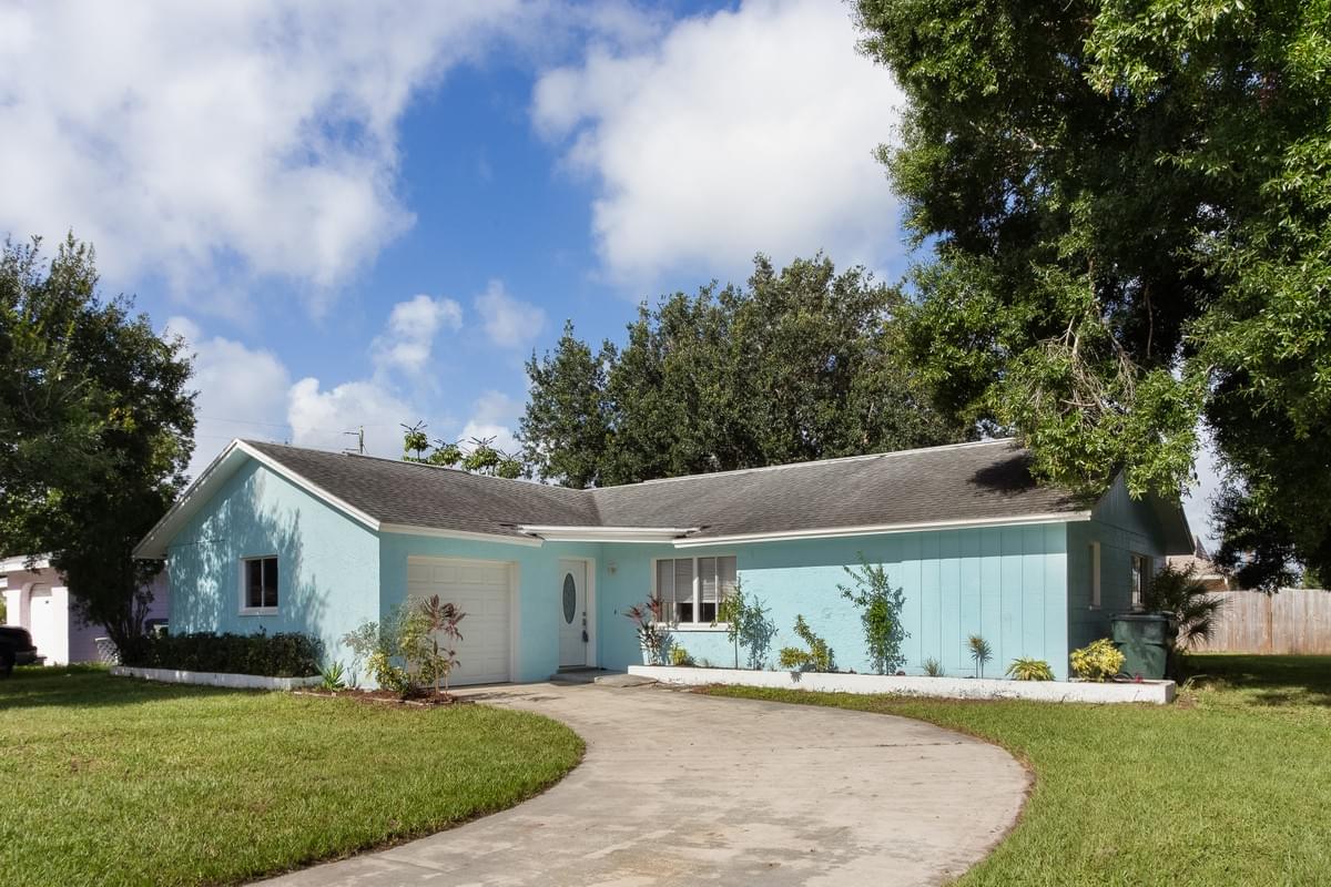 Blue single story home with large oak trees in the yard Blue single story home with large oak trees in the yard