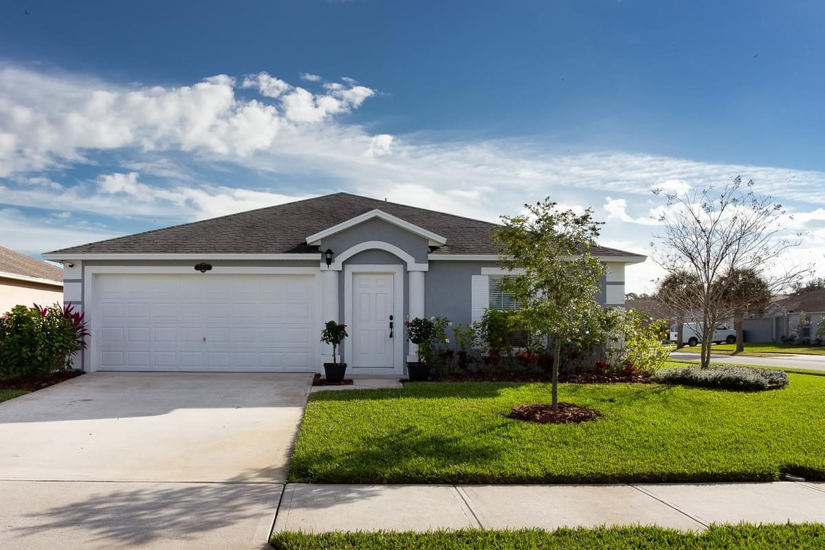 Light grey home with small trees in front Light grey home with small trees in front