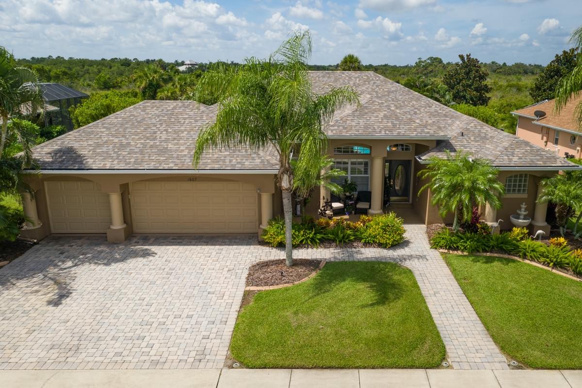 Well manicured tan home with 3 car garage and tropical landscaping Well manicured tan home with 3 car garage and tropical landscaping