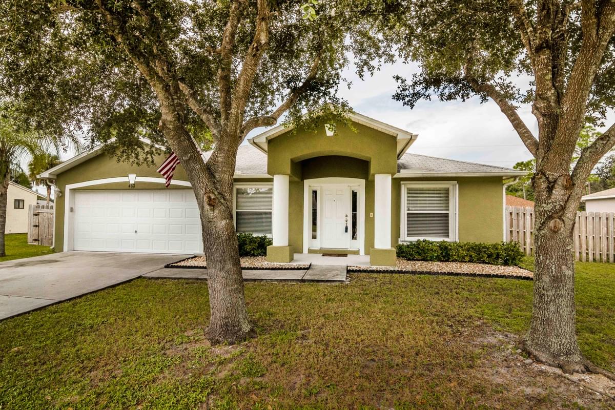 green single story home with large oak trees in front green single story home with large oak trees in front