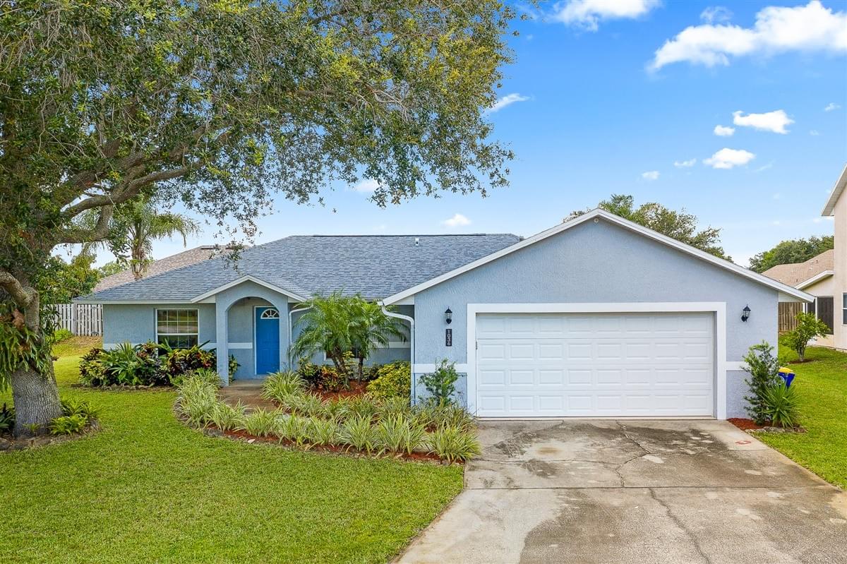Blue single story home with large oak tree in front yard Blue single story home with large oak tree in front yard