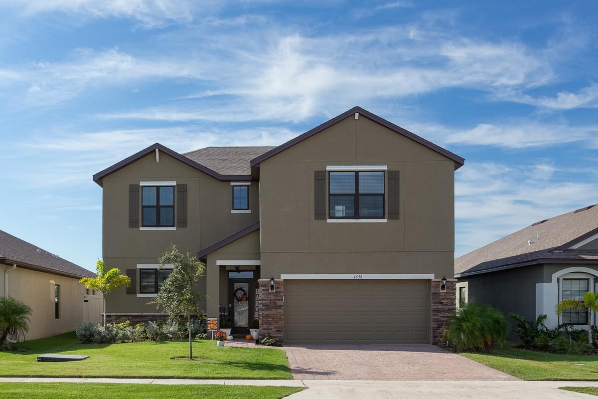 Light brown 2 story home with brick accents. Light brown 2 story home with brick accents.