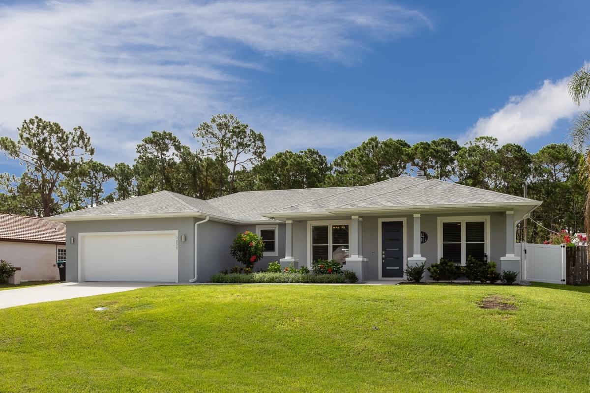 Modern grey home with 2 car garage, with woods behind the home Modern grey home with 2 car garage, with woods behind the home