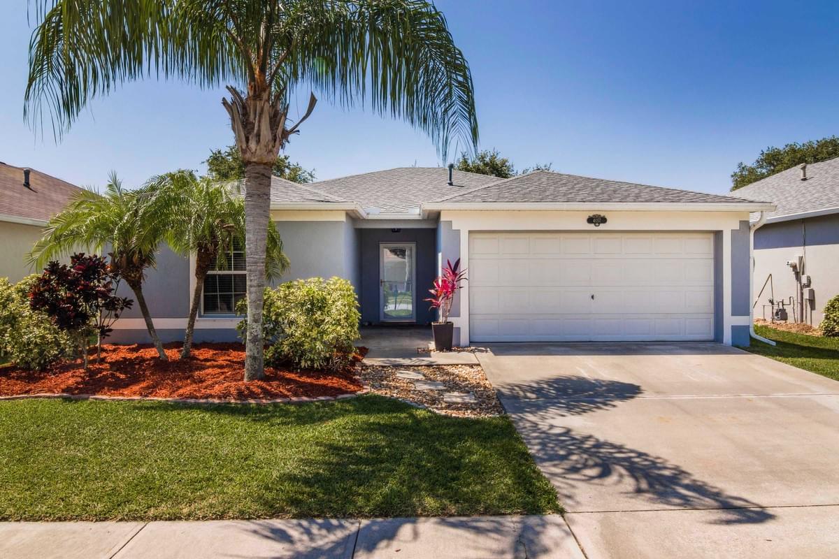 Blue single story home with palm trees in front Blue single story home with palm trees in front