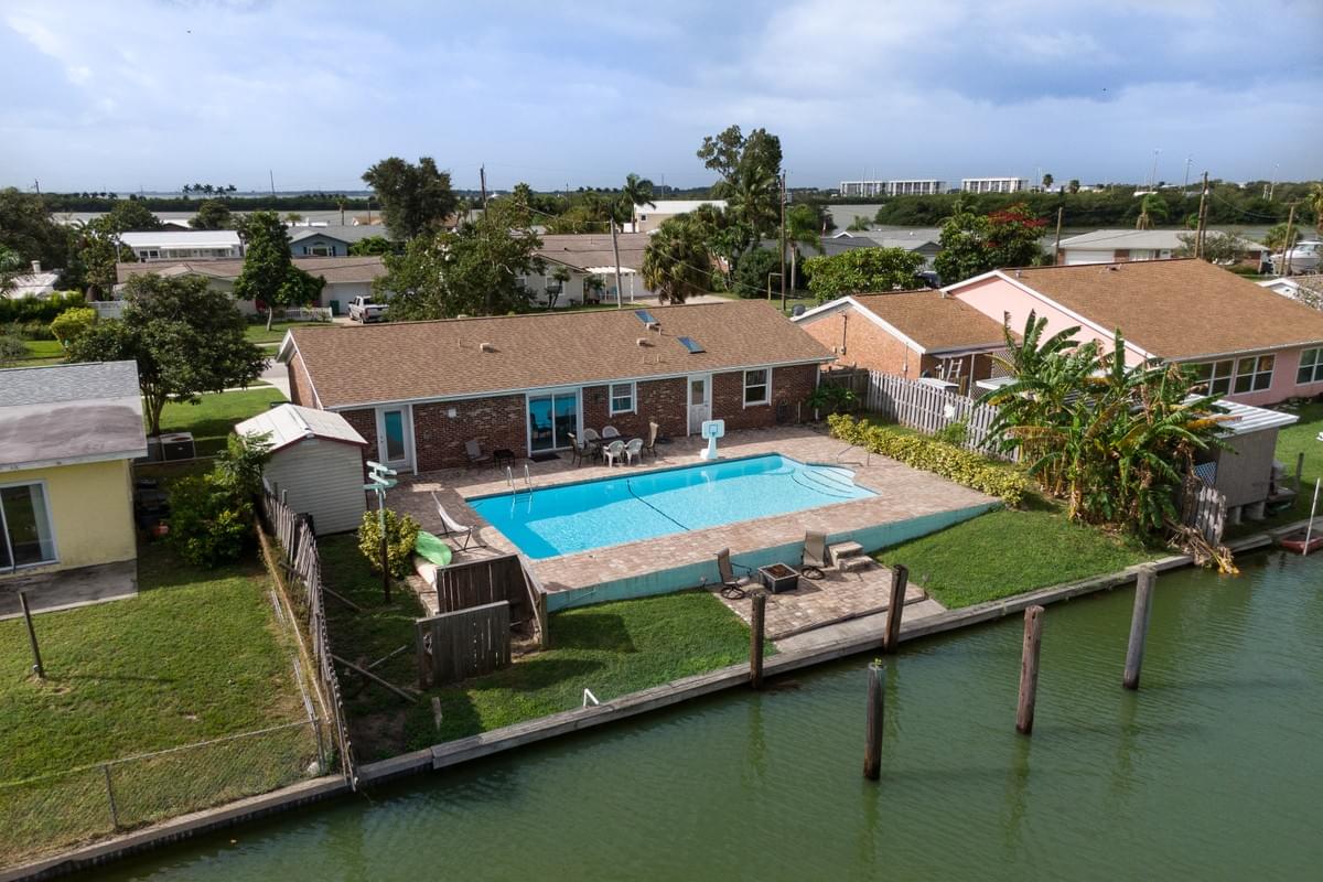 Aerial view of canal front home from the back.  Photo shows the arge swimming pool overlooking the canal. Aerial view of canal front home from the back.  Photo shows the arge swimming pool overlooking the canal.