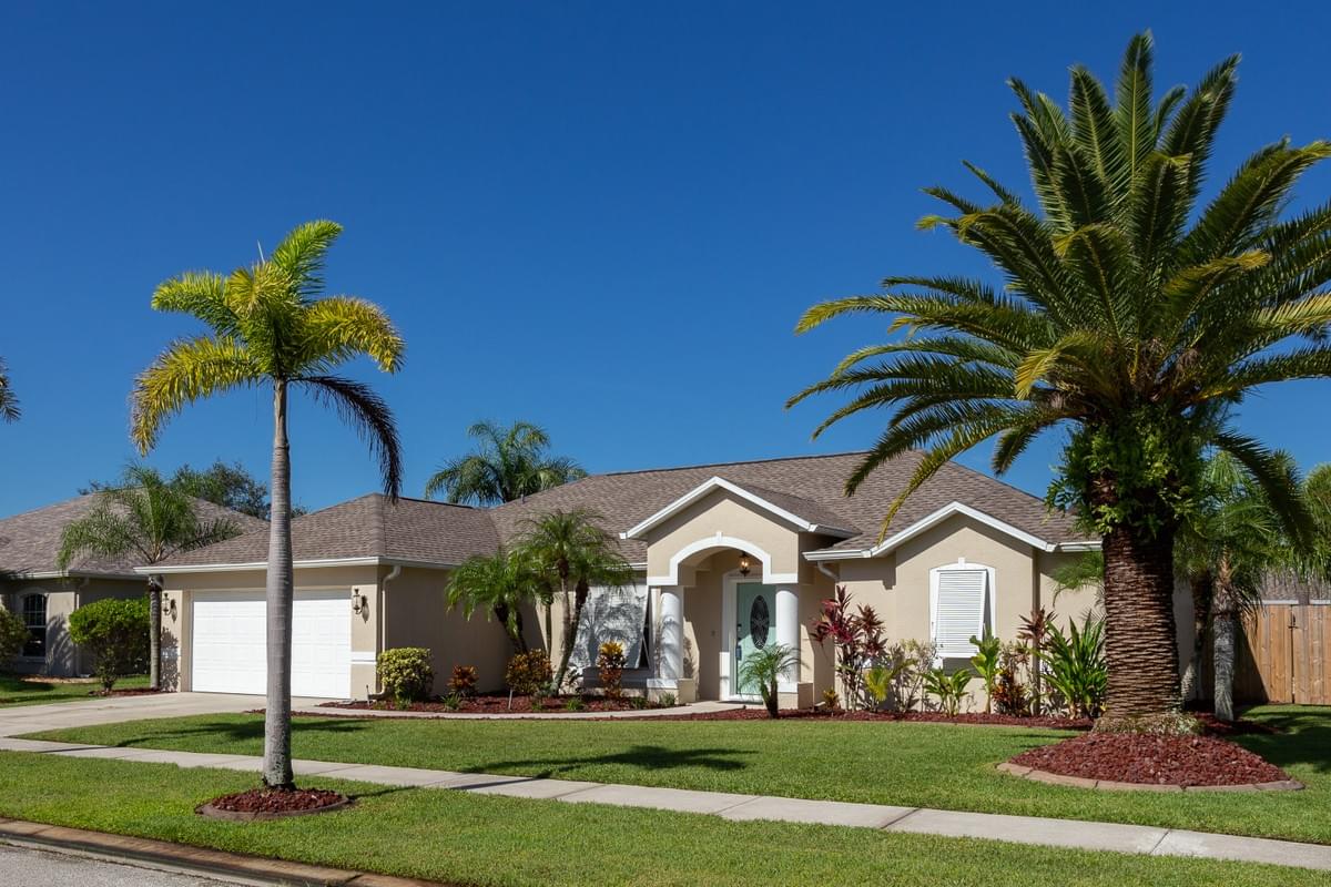 Tan home with white trim and bahama style shutters Tan home with white trim and bahama style shutters