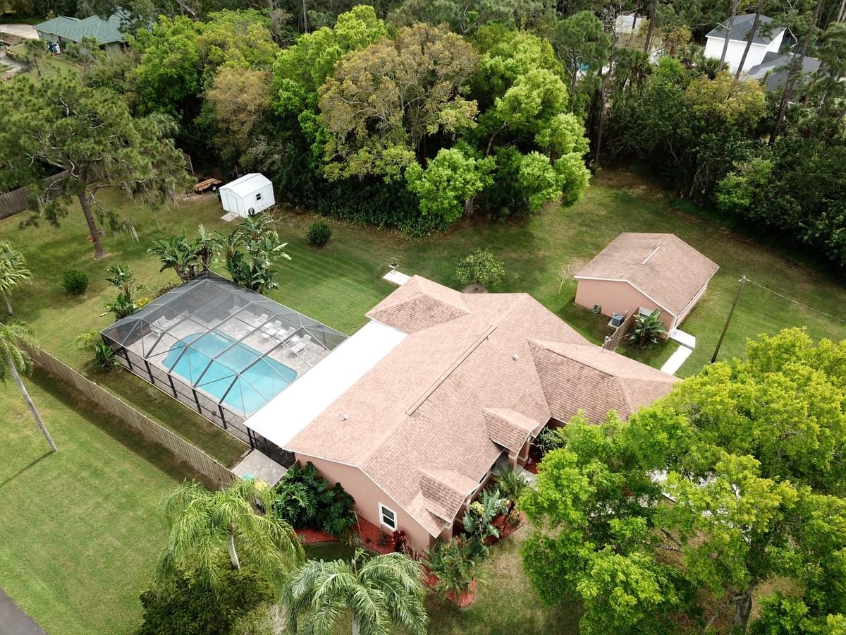 Aerial photo of single story home with a pool and large lot Aerial photo of single story home with a pool and large lot