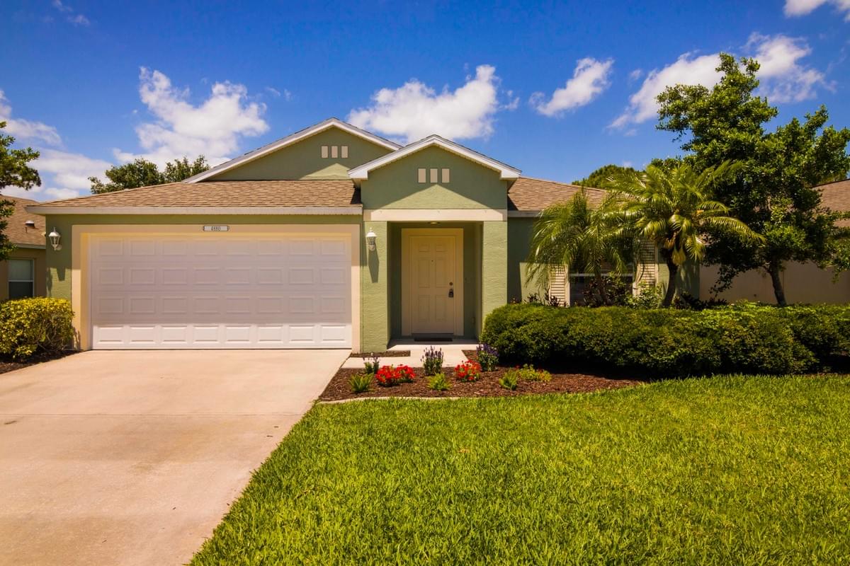 green single story home with small palm trees green single story home with small palm trees