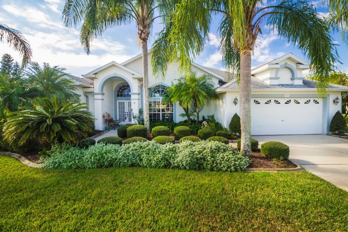 blue and white single story home with palm trees in front blue and white single story home with palm trees in front