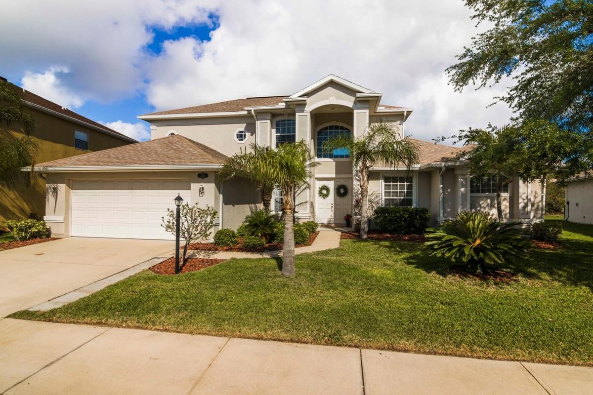 tan two story home with oak trees out front tan two story home with oak trees out front
