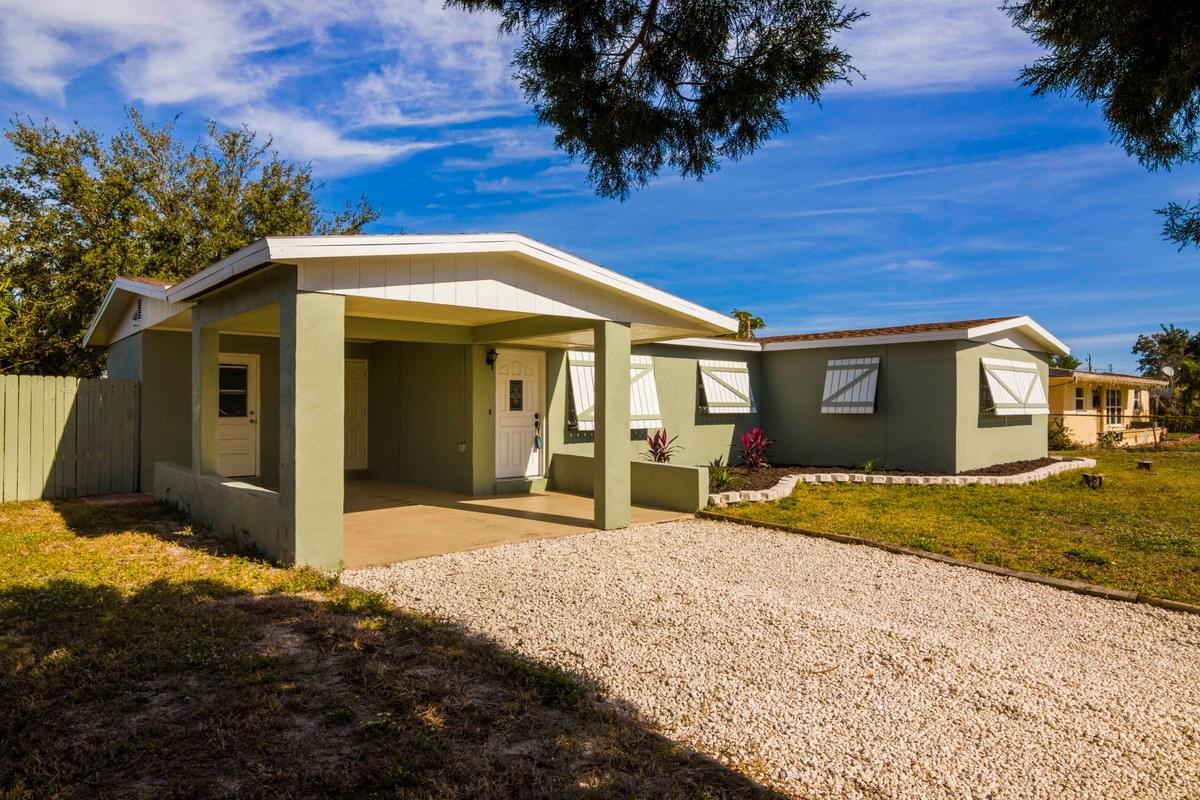 small green single story home, with carport in front small green single story home, with carport in front