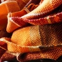 A Cosy Shawl: A Christmas gift from daughter to mother. The brief was for a lightweight but warm, generous sized shawl in a mix of favourite autumnal colours. The idea was that it would be used regularly to bring comfort and keep chilliness at bay. The client also felt that her mother would like a plaid or divided squares/rectangles pattern. There are eight colours combined in this piece.  Made from: 100% British wool blend and a re-cycled acrylic/wool blend. "I commissioned Susan to weave a shawl for my Mum for Christmas and was blown away by what she created. It was a truly collaborative process as I described the colour palette I would like and Susan suggested specific shapes and patterns. It was clear how invested she was and so thoughtful in her approach. I was able to give my mother a beautiful, unique gift that she absolutely loved. Thank you, thank you , thank you!". (Fiona, Surrey)