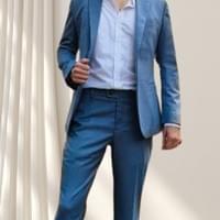 Relaxed businessman in a tailored blue suit — fit and fabric signalling readiness and quiet confidence.