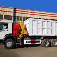 Tipper truck with folding arm 