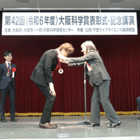  記念品贈呈　授与者： 千里ライフサイエンス振興財団　理事長代理　小原　理恵 氏（専務理事）