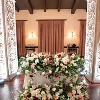High impact sweetheart table with flowers draping down the front of the table