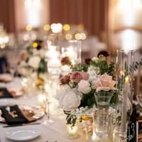 Candlelight wedding table with low centerpiece featuring mauve and white flowers