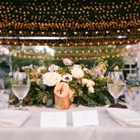 Wedding table design, rustic style, and drapped twinkle market lights above