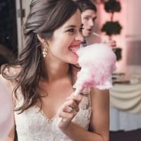 Bride enjoying cotton candy vendor at her wedding
