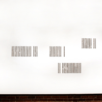 59 Pieces. A handwoven fragment was slowly cut apart to create this work. Its disappearance is documented in the work. Concrete, handwoven cotton, dimensions vary.