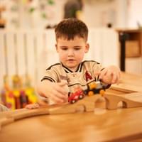 Child building a wooden train track