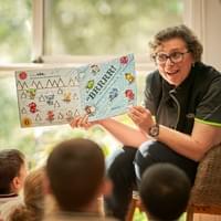 Educator reading a picture book to children