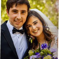 Happy wedding couple featuring purple and green bridal bouquet