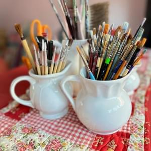 Paintbrushes in antique pitchers