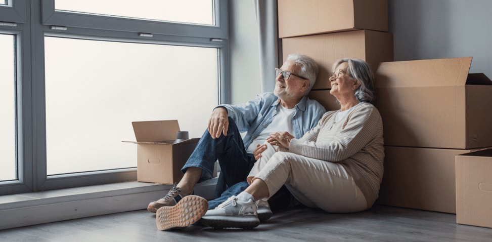 Senior couple sitting beside moving boxes