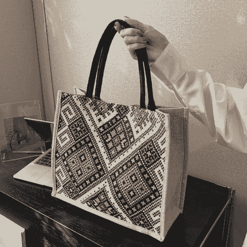 Bolsa tote de tecido com estampa geométrica colorida.