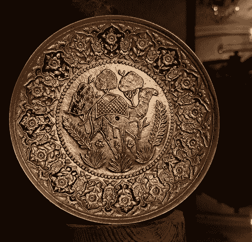 صحن ديكور نحاسي مزخرف بنقش يدوي فني مميز، يتوسطه جمل مزخرف بتفاصيل دقيقة ومحاط بزخارف زهرية ملونة