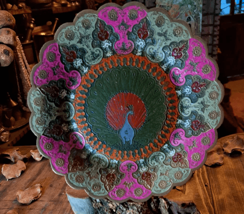 هذا طبق زخرفي فني نادر بتصميم مستوحى من الفن الشرقي، يتميّز بشكل دائري وحواف متموّجة، ويتوسطه طائر