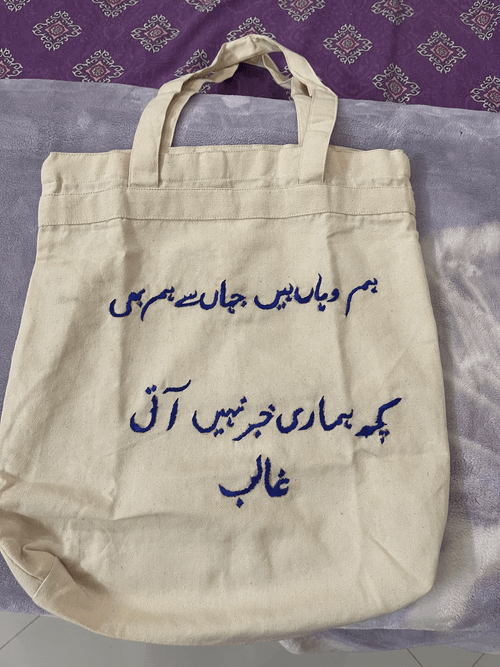 White bag with purple urdu writing